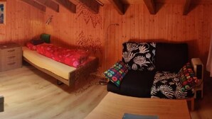 A wooden room with a bed, a chair, and a small table. - im Gründli by Interhome (Wildhaus)