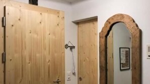 Un pasillo con puertas de madera y un espejo en la pared.
