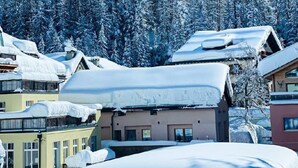 Un village de montagne enneigé, avec des bâtiments et un ciel bleu dégagé.