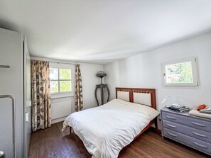 A bedroom with a bed, a dresser, a lamp, and a window. - Maisonette Alpenrose by Interhome (Sils Maria)