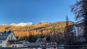 Une vue sur une montagne, avec un bâtiment de style chalet et un fauteuil au premier plan.