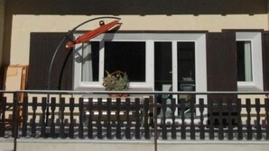 Een berghut met een houten terras en een skilift op de achtergrond.