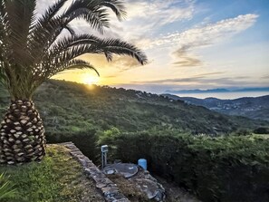A palm tree, a stone wall, and a distant view of a town with mountains. - Chalet 'Panorama' mit Infinity-Pool by Interhome (Giungano)