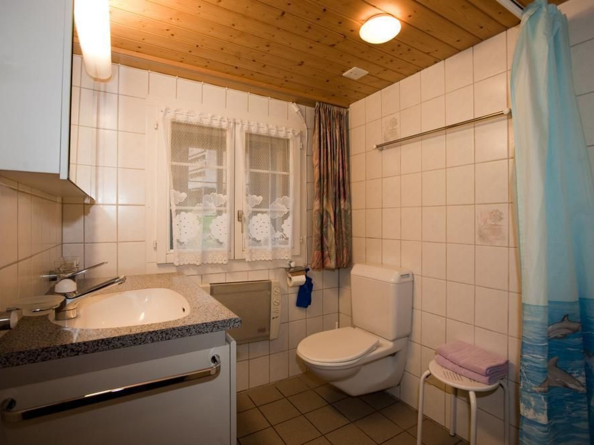 A bathroom with a sink, toilet, and shower curtain.