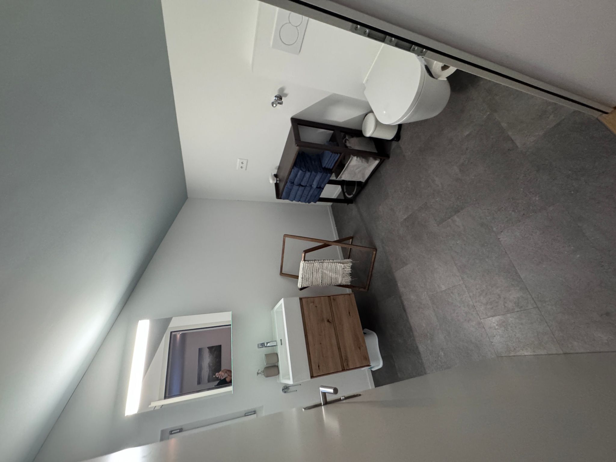 Un baño moderno con inodoro, lavamanos y una ventana pequeña.