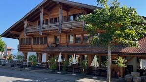 A wooden building with a balcony, outdoor seating, and a sign that reads "Sagi". - Pfrundmatte 12 by Interhome (Aeschi bei Spiez)