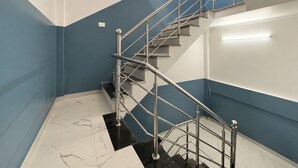 Eine moderne Treppe mit Metallgeländer, Marmorstufen und einer blauen Akzentwand.