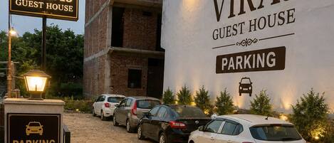 A guest house named VIRAJ with a sign indicating parking availability.