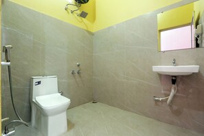 Een badkamer met een toilet, douche en wastafel.