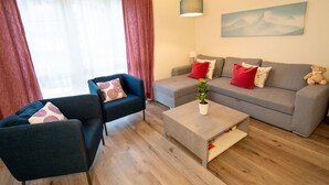 A modern living room with a sofa, two armchairs, a coffee table, and a painting on the wall. - Gina's Apartment - Nähe zu See und Berge by Interhome (Sarnen)