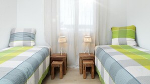 A bedroom with two beds, each with a striped pillow and a lamp on a wooden nightstand. - Gina's Apartment - Nähe zu See und Berge by Interhome (Sarnen)