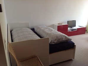 Ein Schlafzimmer mit einem Bett, einem Fernseher und einem kleinen Schreibtisch.