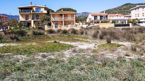 A coastal residential area with multi-story buildings, some with balconies, and a clear sky. - La Playa Wohnung - direkt am Strand by Interhome (La Caletta)