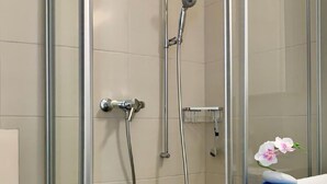 Eine Duschkabine mit Handbrause und Wandarmatur.