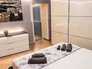 Une chambre à coucher moderne, avec un lit, une table de chevet, une commode et un globe terrestre fixé au mur.