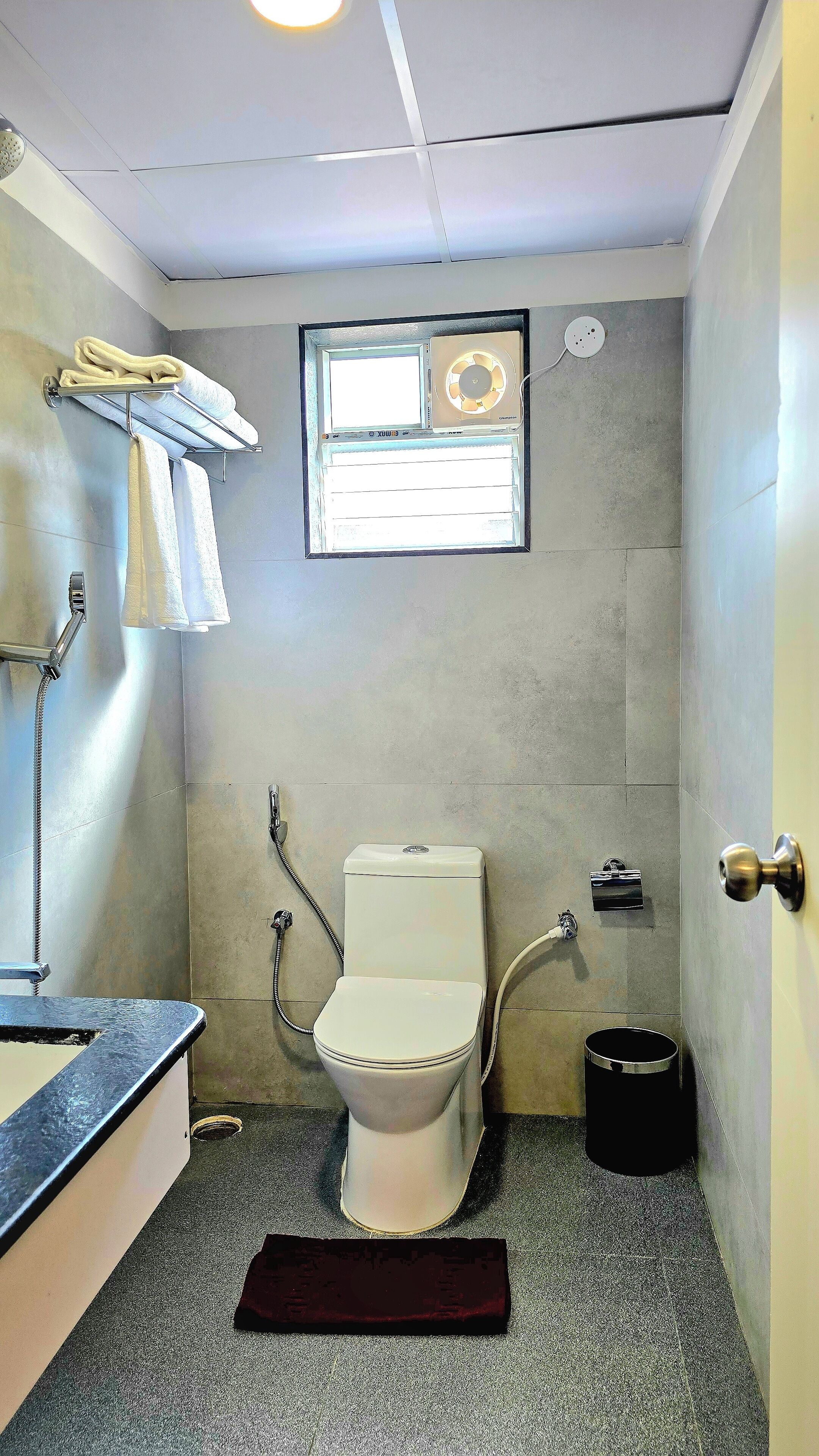 Ein kleines Badezimmer mit Toilette, Dusche und Handtuchhalter.