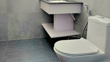 Un baño con inodoro, lavamanos y espejo.