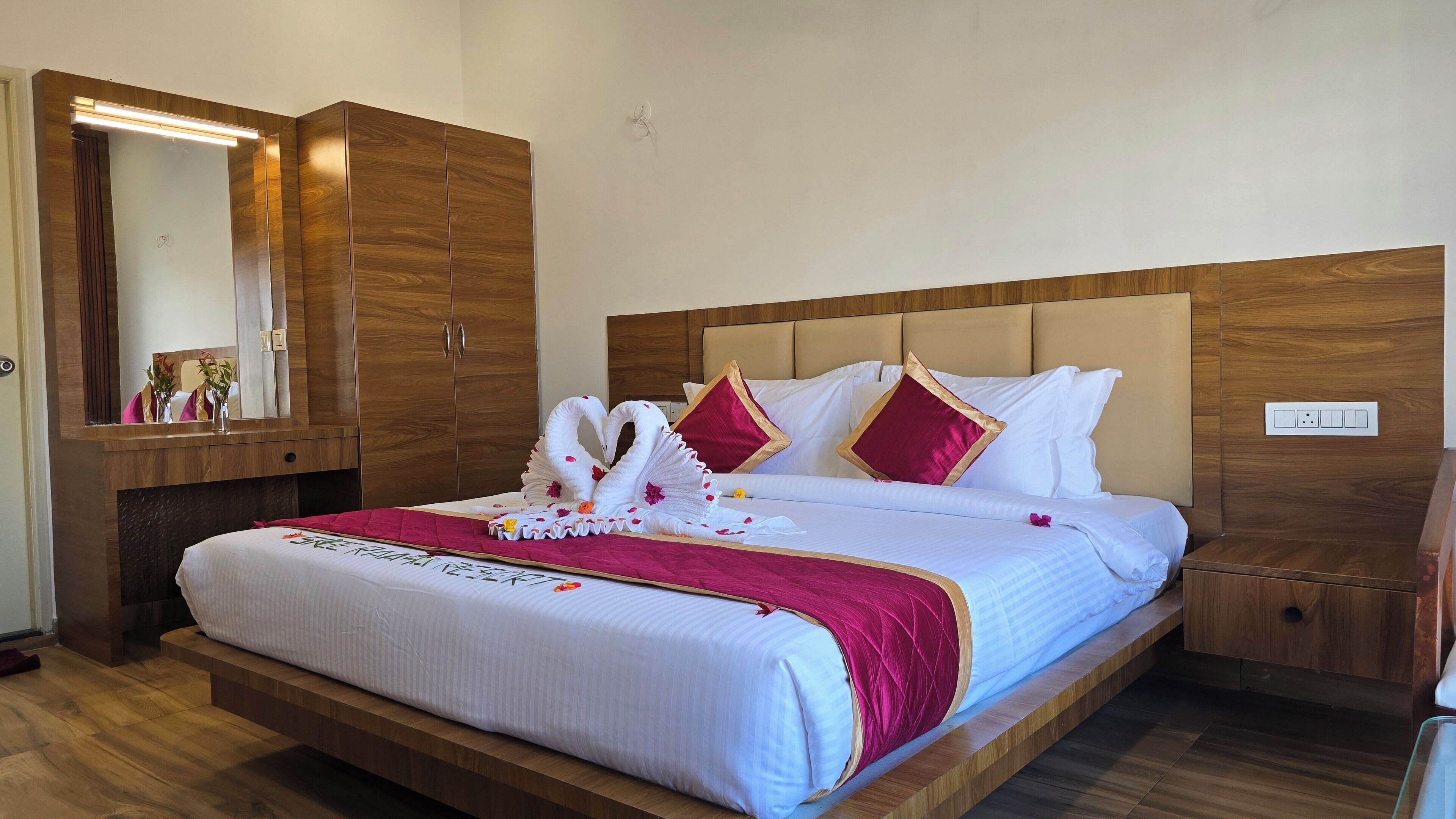 Une chambre d’hôtel avec un grand lit, une tête de lit en bois et une armoire en bois.