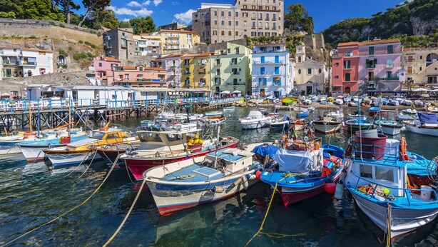 A marina with numerous boats docked, surrounded by colorful buildings and a clear blue sky. - Monolocale ROSA by Interhome (Sorrento)