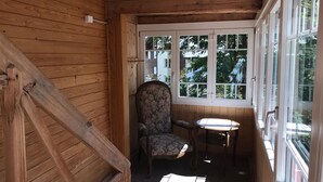 A wooden interior with a chair and a small table near a window. - Chalet Alpenblick 4-Bett Wohnung by Interhome (Lauterbrunnen)