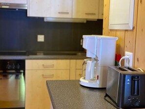 Een koelkast, een microgolfoven, een oven, kookgerei, borden en bestek