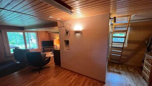 Une pièce avec un plancher en bois, une télévision, un bureau et une chaise.