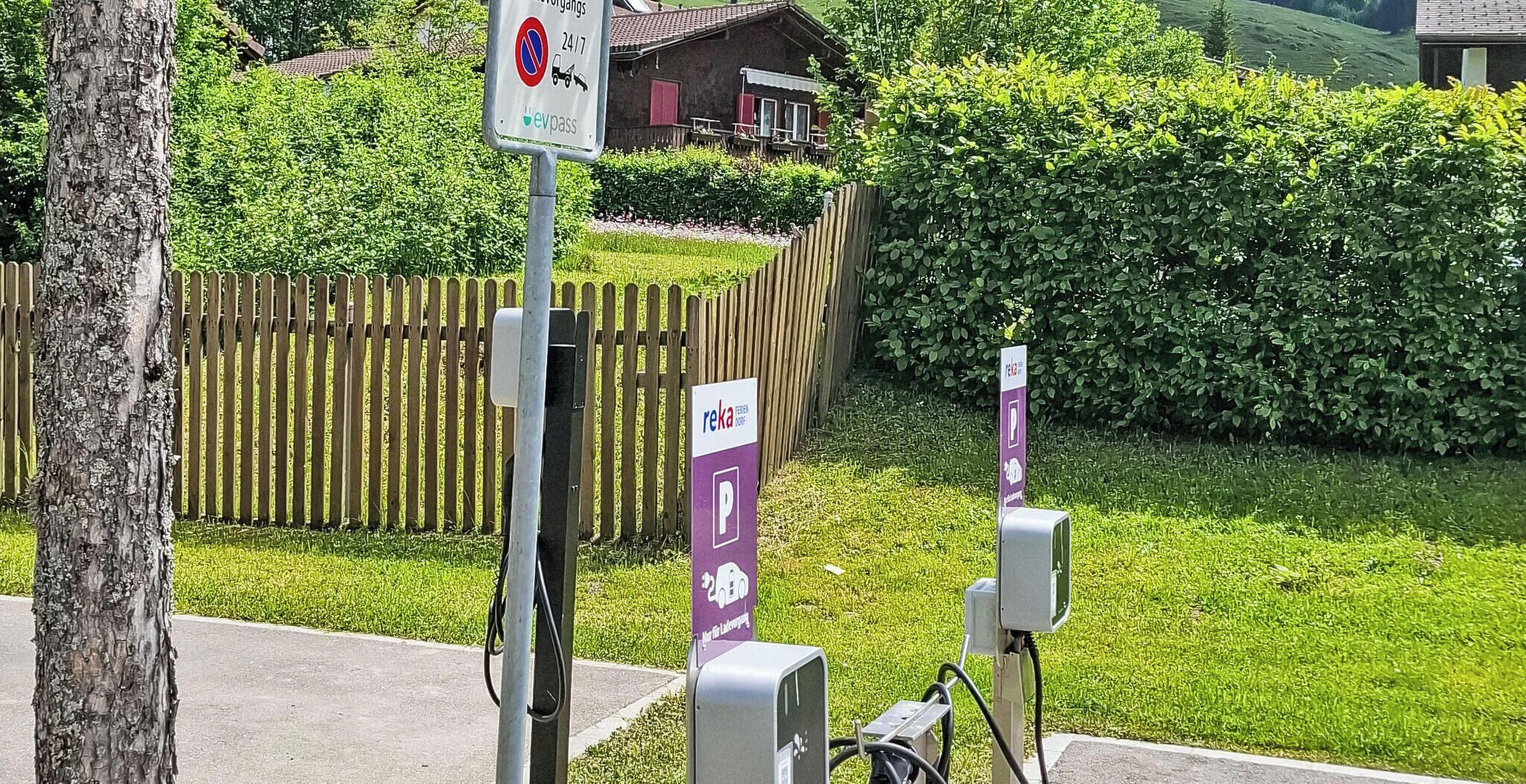 Ein Parkplatz mit Ladestationen für Elektrofahrzeuge und einem Schild, das Parkverbote anzeigt.