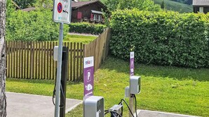 En parkeringsplats med laddstationer för elfordon och en skylt som visar att parkering inte är tillåten för andra fordon.