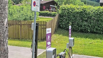Ein Parkplatz mit Ladestationen für Elektrofahrzeuge und einem Schild, das Parkverbote anzeigt.