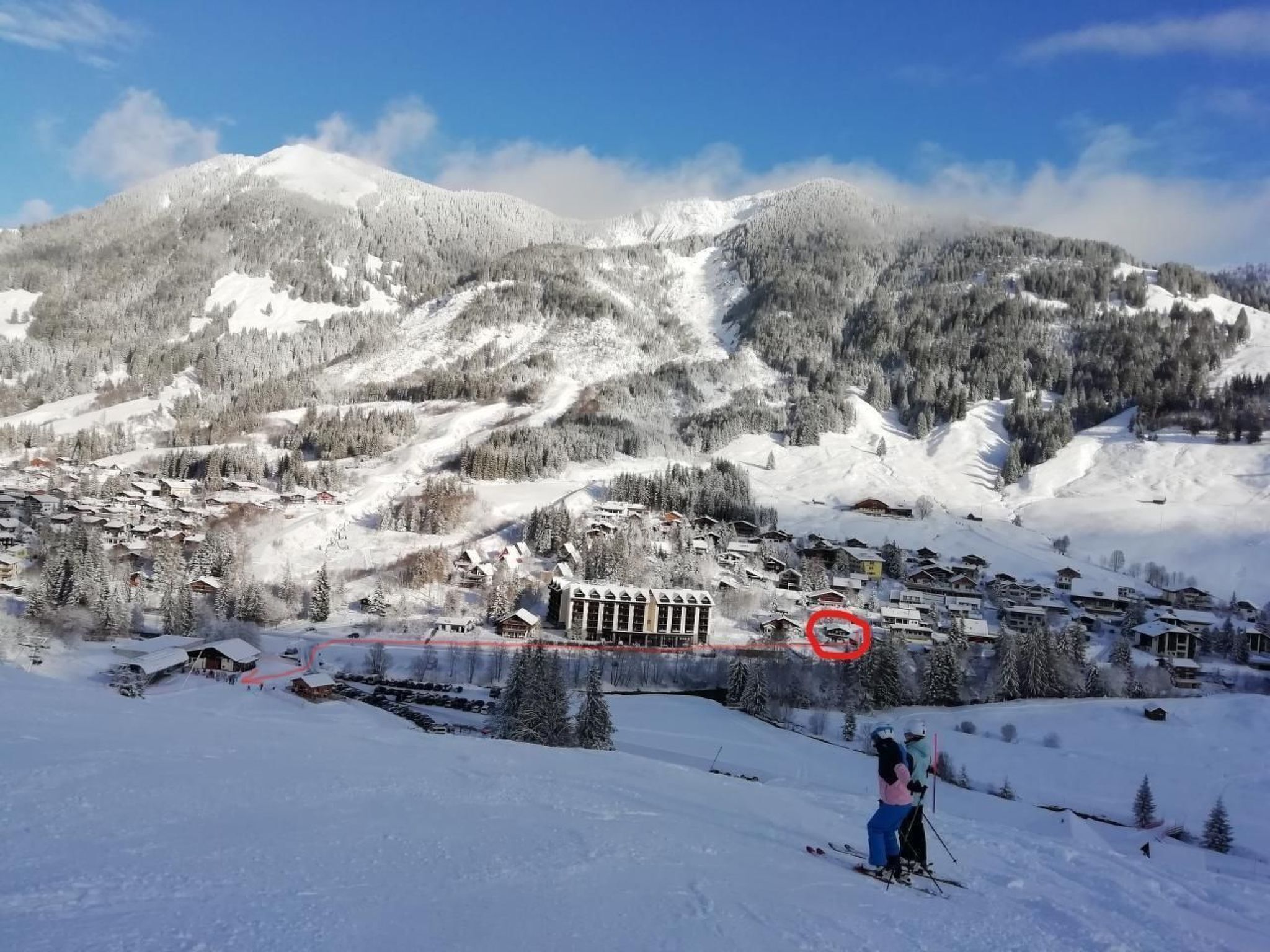 Un village de montagne enneigé, avec des bâtiments et des pistes de ski.