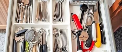 Un cajón con diversos utensilios de cocina organizados en compartimentos.