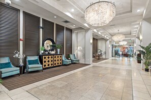 Eine geräumige Lobby im modernen Stil mit Empfangsschalter, Sitzgelegenheiten und dekorativer Beleuchtung.