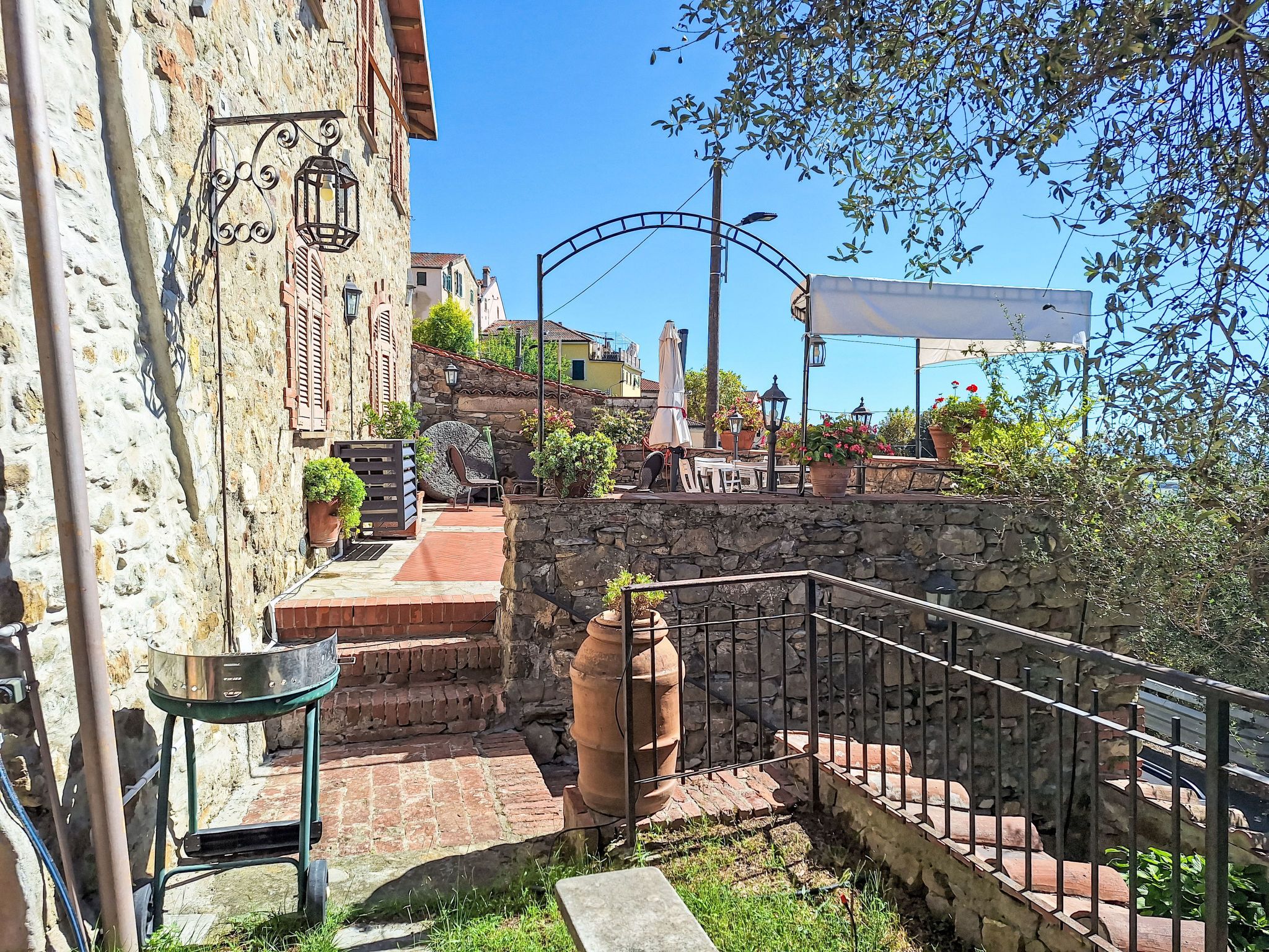 A stone building with a metal railing, a staircase, and a view of a street with a lamppost.