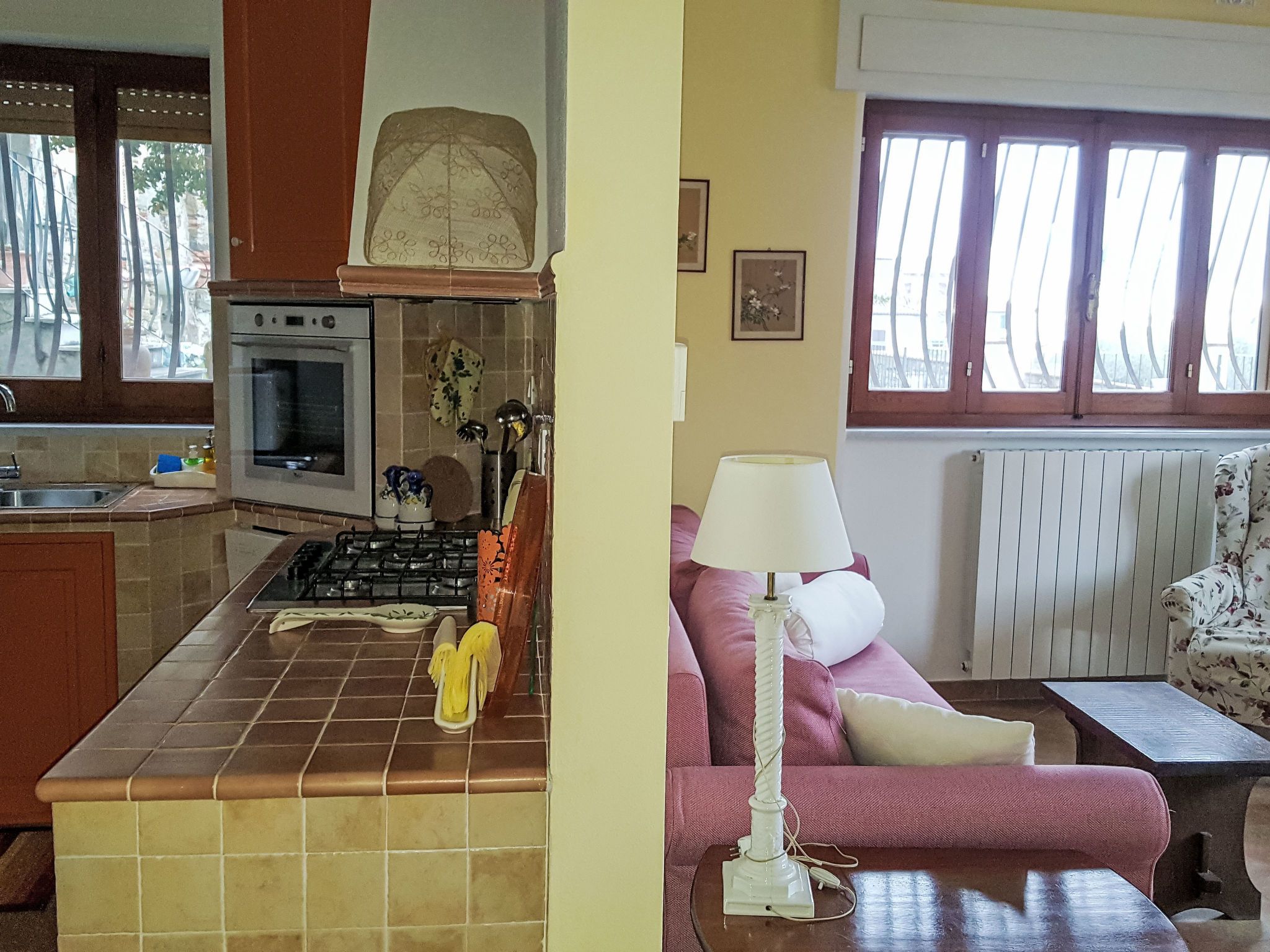 Uma cozinha com fogão, forno e pia, uma área de jantar com mesa e cadeiras, e uma janela com vista para o exterior.