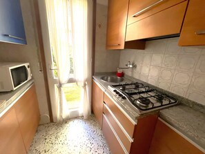 Kühlschrank, Herdplatte, Kochgeschirr/Geschirr/Besteck, Esstisch