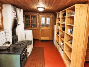 Een koelkast, een oven, een vaatwasser, kookgerei, borden en bestek