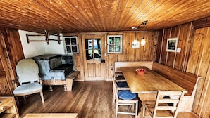 Un intérieur en bois avec une table à manger, des bancs et un canapé.