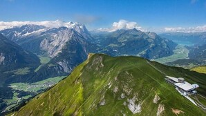 Un paisaje montañoso con un edificio sobre una colina.
