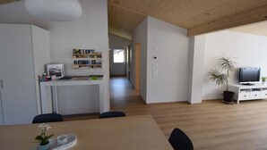 A modern interior with a dining area, kitchen, and living space. - Gemeindematte „Sommer Bergbahnen inklusive“ by Interhome (Meiringen)