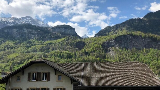 A mountain landscape with a house featuring a sloped roof and wooden siding. - Gemeindematte „Sommer Bergbahnen inklusive“ by Interhome (Meiringen)