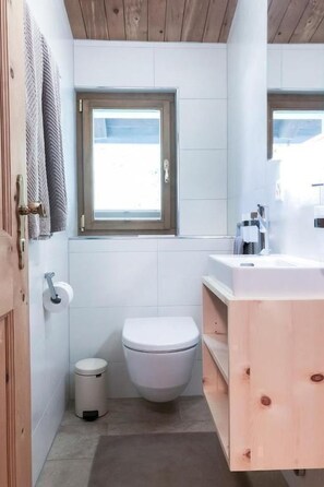 Un baño pequeño con inodoro, lavamanos y ventana.