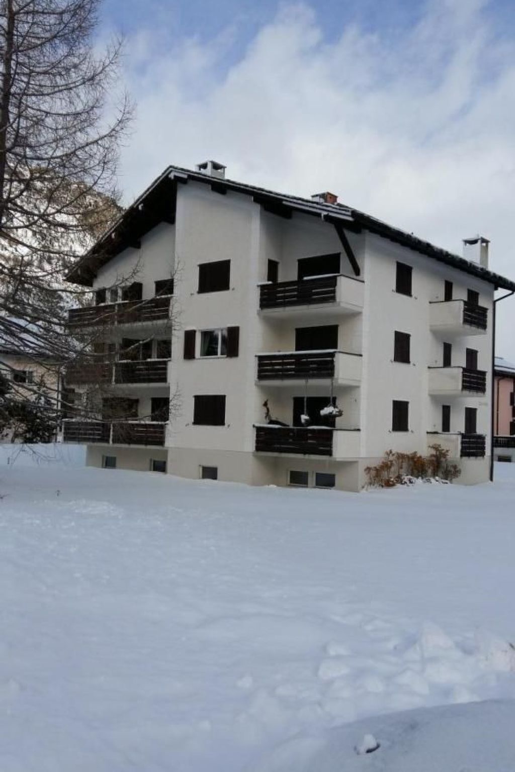 Un edifici d'àmples terrasses encalades, envoltat de neu.