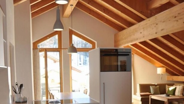 A modern kitchen with white cabinetry, a built-in oven, and pendant lighting. - Chesa Sunasain V11 by Interhome (Sils Maria)