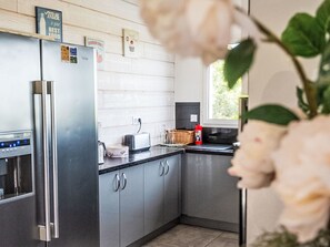 A modern kitchen with a stainless steel refrigerator, a toaster, and a window with a view of greenery. - Ein gemütliches Nest im Herzen der Ardèche Méridionnale by Interhome (Largentière)