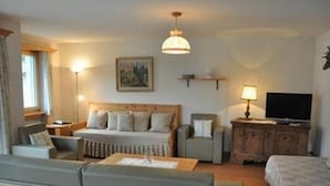 Een knus hotelkamer met een bed, een sofa, een bureau en een televisie.