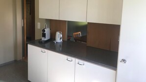 A compact kitchen with white cabinets, a black countertop, and a coffee maker. - Soldanella by Interhome (Appenzell)