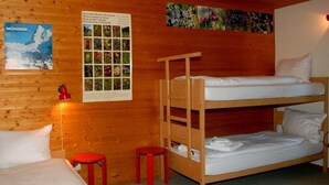 A wooden cabin room with bunk beds, a poster of plants, and a red lamp. - Chalet Crystal by Interhome (Lauterbrunnen)
