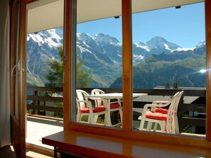 Uma varanda com vista para montanhas cobertas de neve.