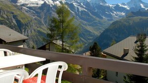A mountain view with a chalet and a dining area with a table and chairs. - Chalet Crystal by Interhome (Lauterbrunnen)
