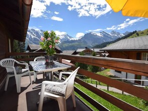 A balcony with a table and chairs, overlooking a mountainous landscape. - Apartment West by Interhome (Lauterbrunnen)